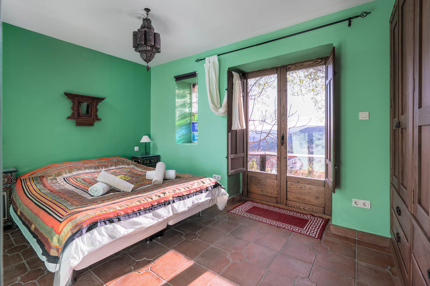 Habitación configurada con cama doble y salida a terraza