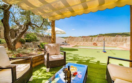 Zona con sombra amueblada junto a la piscina