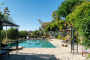 The pool is surrounded by lush gardens