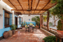 Amplia terraza con pérgola delante de la casa